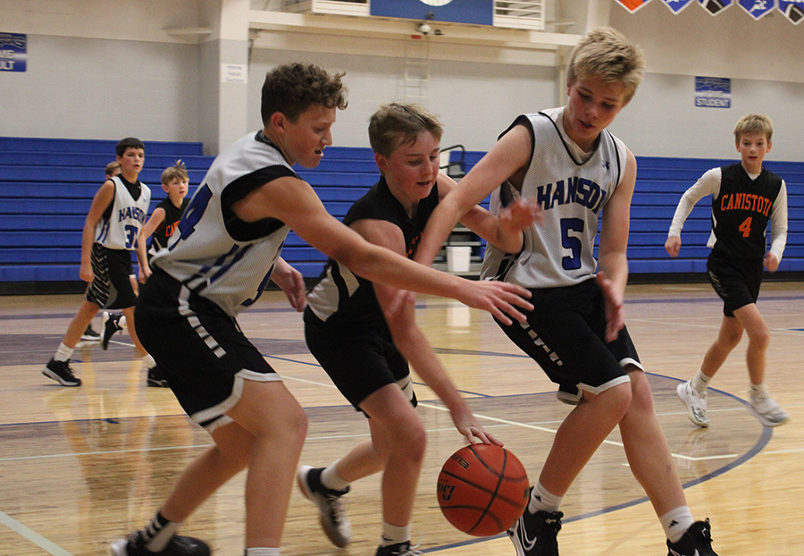 Sutton Squires (left) and Conner Endorf (right) battle a Canistota player for the ball during Tuesday night’s game.